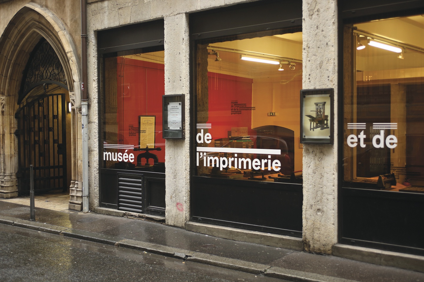 Déploiement du logotype sur les vitrines extérieures du Musée, rue de la Poulaillerie, Lyon 2/e :<div>le logotype se réorganise sur les cinq vitrines et met en œuvre le principe d’identité mobile.</div>